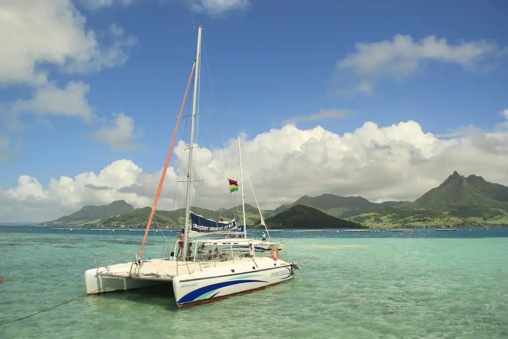 Catamaran flying the Mauritius flag in a turquoise lagoon